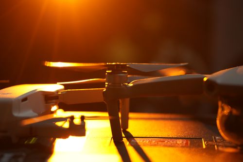 Free A drone's silhouette against the warm glow of a setting sun, emphasizing technology and nature. Stock Photo