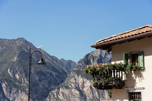 Free Picturesque balcony with flowers set against majestic mountain landscape under clear sky. Stock Photo
