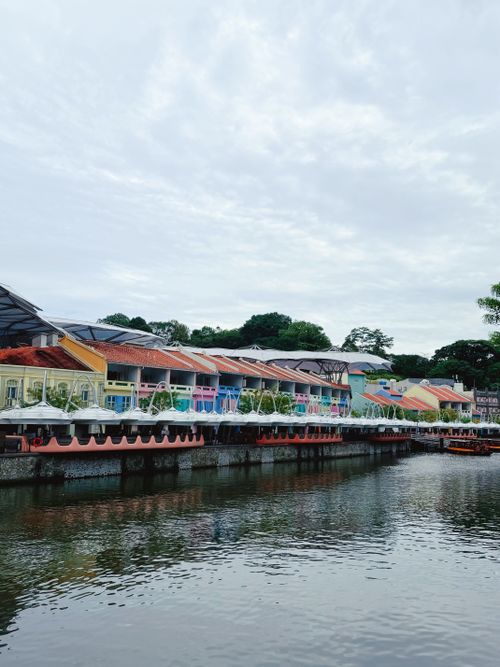 Free Vibrant riverside architecture with colorful buildings reflecting in water, creating a serene urban scene. Stock Photo