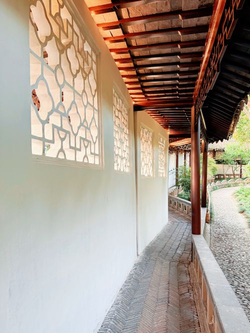 Free Peaceful walkway through traditional Asian architecture with intricate lattice windows. Stock Photo