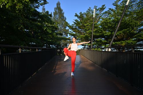 Free Woman performing yoga on a scenic bridge in Jawa Barat, Indonesia, surrounded by lush greenery. Stock Photo