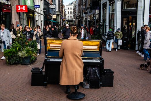 A street musician plays the piano in a busy urban setting, captivating onlookers with live music.