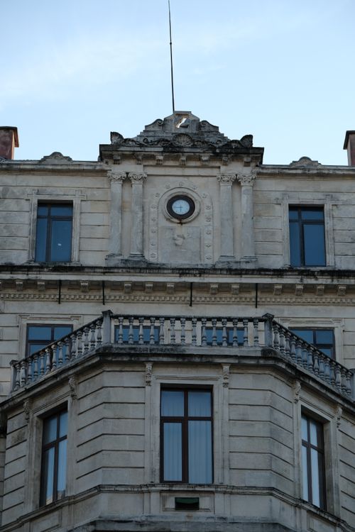 Free Close-up of a historic European building facade featuring a decorative clock. Stock Photo