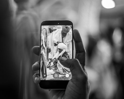 Free A close-up of a person filming an event on a smartphone, captured in black and white. Stock Photo
