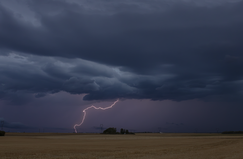 Free A powerful lightning storm electrifies the night sky over a rural field, illustrating nature's drama. Stock Photo