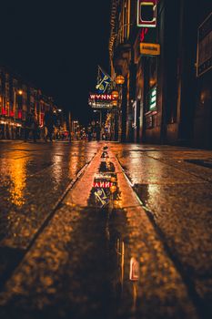 Explore the lively nightlife of Dublin City with neon lights reflecting on wet pavements. Captivating urban scene.