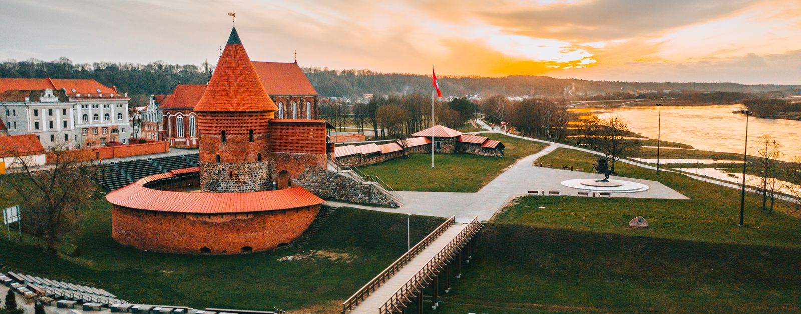 Stunning aerial view of historic Kaunas Castle in Lithuania during golden hour, showcasing vibrant skyline.