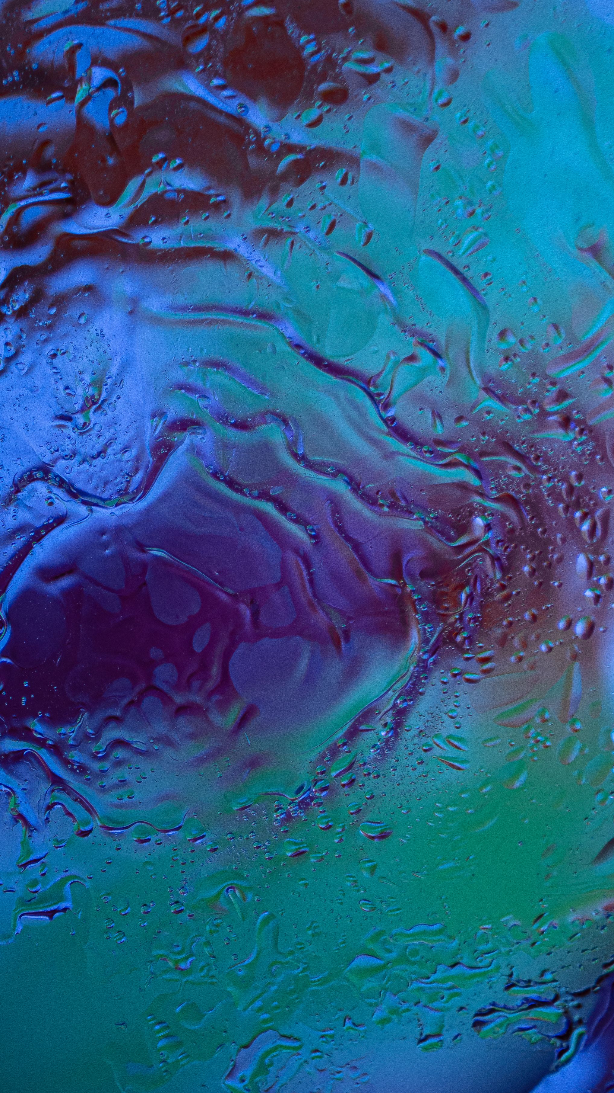 A vibrant and colorful abstract background with water texture, blending hues of blue, purple, and green.