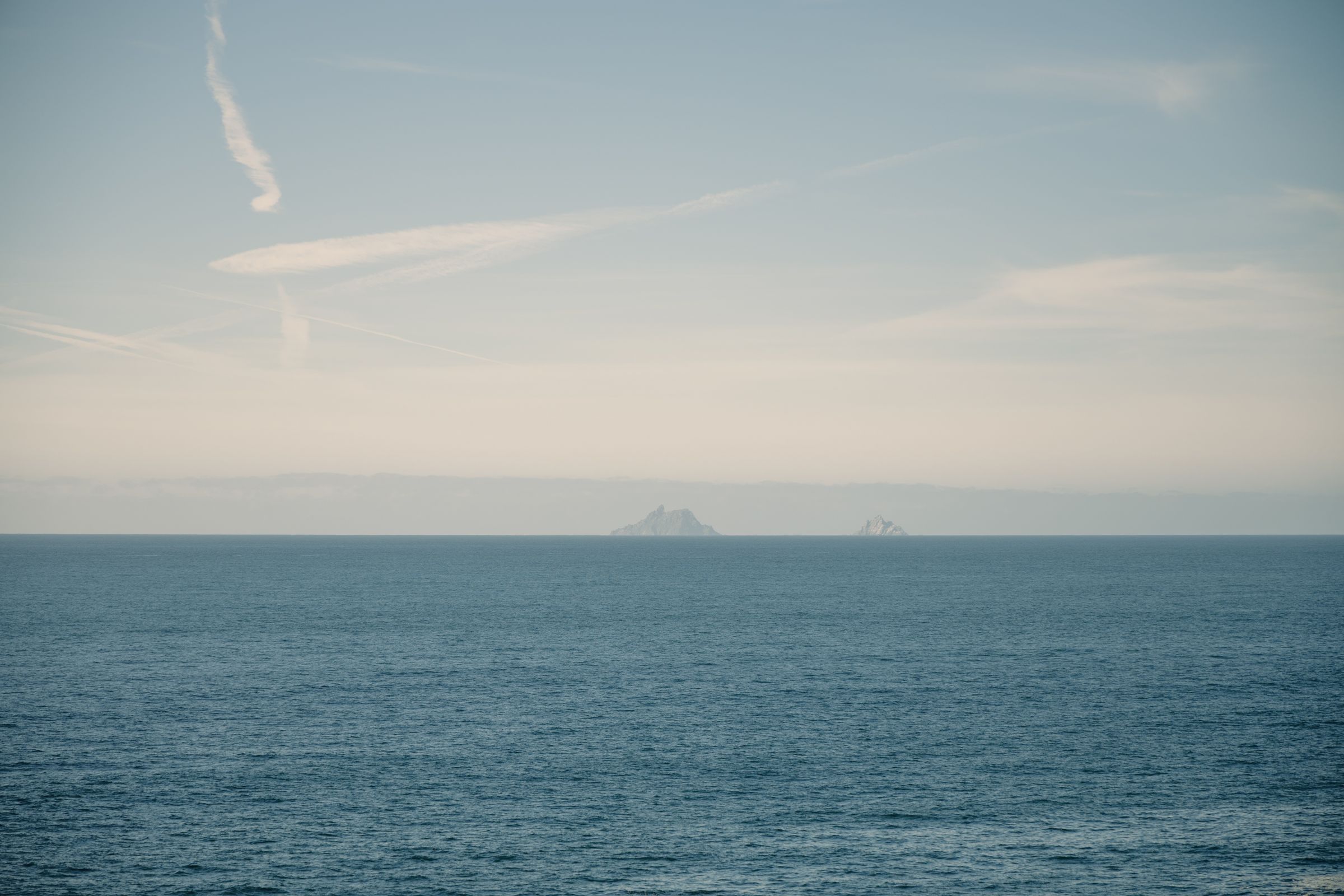 Calm ocean view with distant islands under a clear sky, in Ireland
