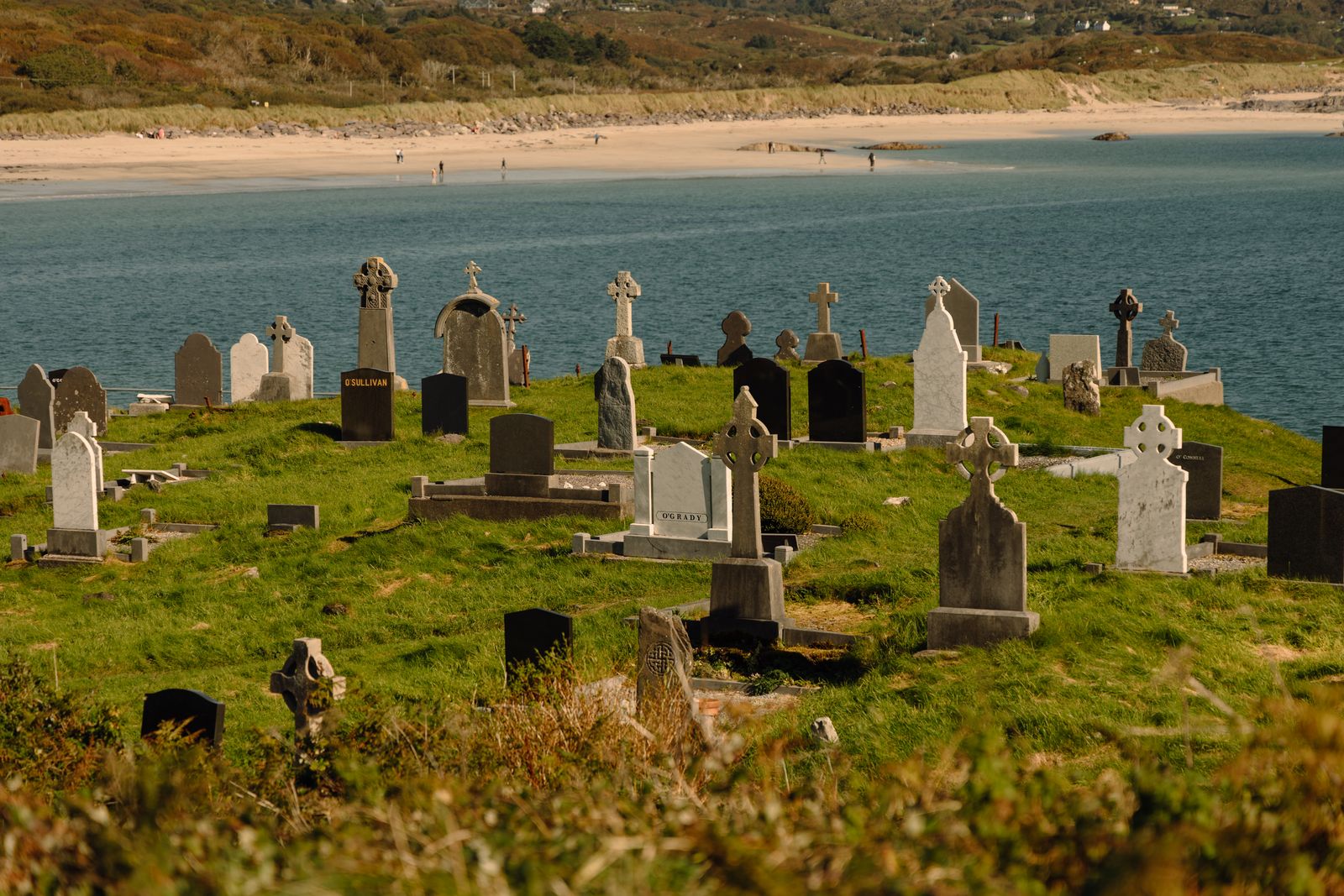 Coastal cemetery in Ireland with stone graves overlooking the ocean on a sunny day