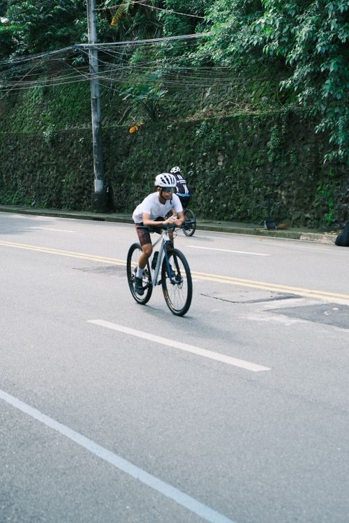 Free Cyclist riding on a city street, showcasing fitness and endurance. Stock Photo