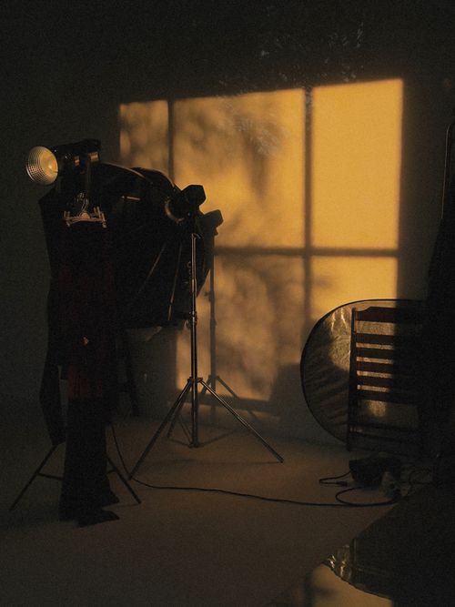 Free A studio scene with dramatic lighting casting shadows on the wall, featuring photography equipment. Stock Photo