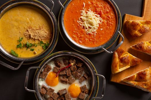 Assorted Mediterranean dishes with bread on a wooden board.
