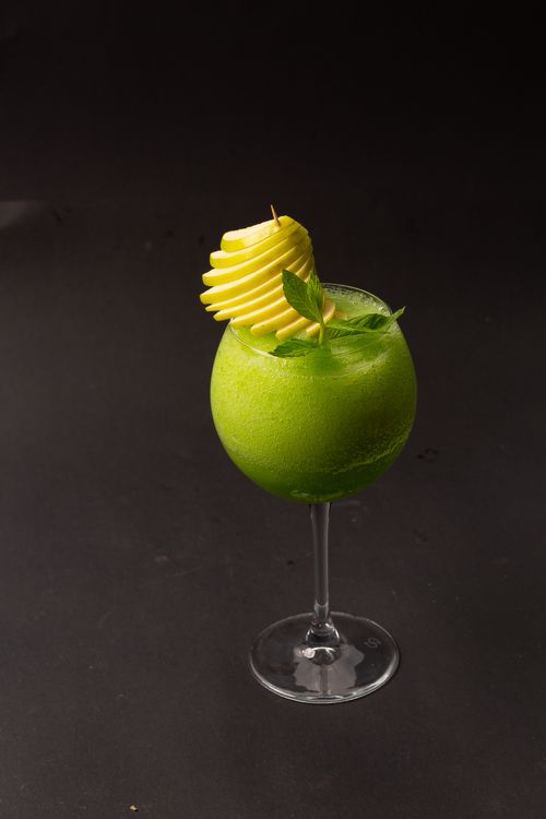Free Refreshing green apple mint cocktail with elegant garnish on a dark background. Stock Photo