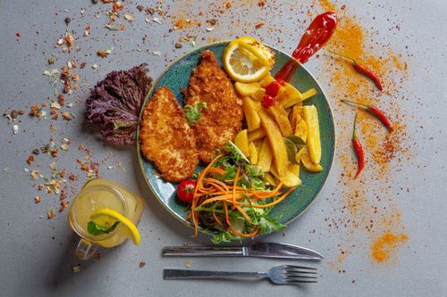 Free Crispy fried chicken breast with fries, salad, and a lemon drink. Stock Photo