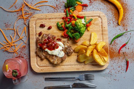 Delicious gourmet meal with grilled chicken, vegetables, wedges, and a refreshing drink.