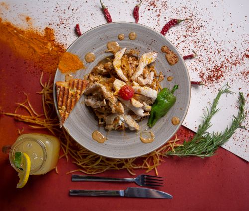 Free Delicious gourmet chicken dish with a blend of spices, rosemary, and a refreshing citrus drink, perfect for a flavorful meal. Stock Photo