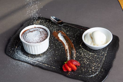 Delicious chocolate soufflé dessert served with vanilla ice cream and fresh strawberries.