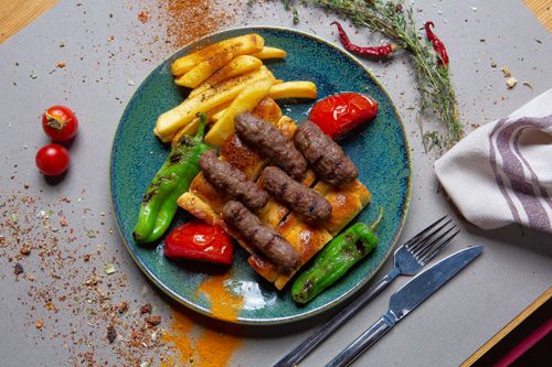 Free Grilled skewers with vegetables and fries on a plate. Perfect for a flavorful meal. Stock Photo