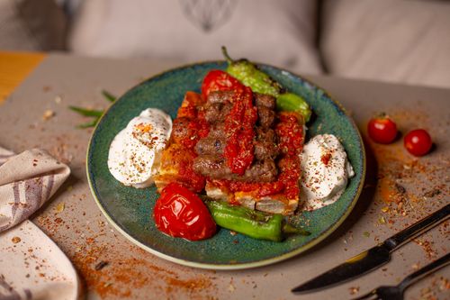 Free Appetizing grilled kebab served with yogurt, peppers, and tomato sauce on a plate. Stock Photo