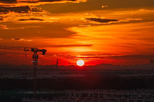 Free Dramatic sunset over Haiphong, Vietnam, highlighting construction cranes against the vivid sky. Stock Photo
