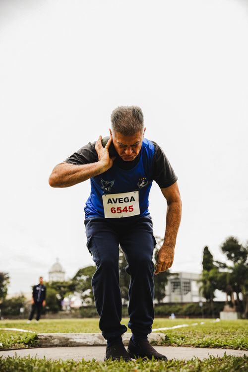Free Senior male athlete prepares to throw shot put at outdoor event. Stock Photo