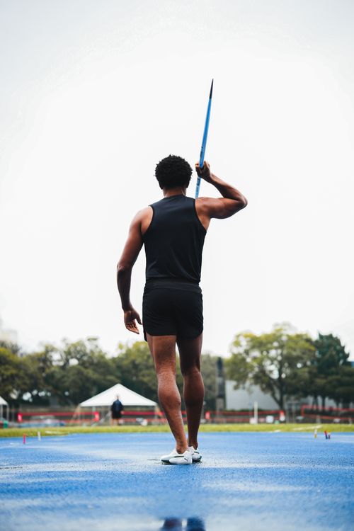 Free Male athlete ready for a javelin throw during a track event on a bright day outdoors. Stock Photo