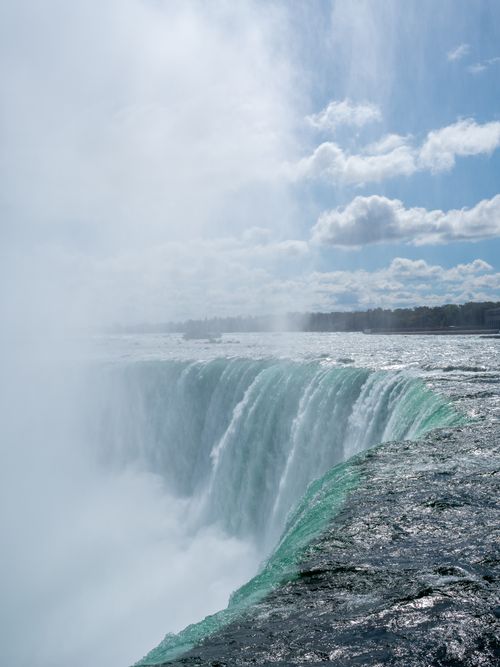 Free Captivating view of the powerful Niagara Falls on a sunny day with mist and blue sky. Stock Photo