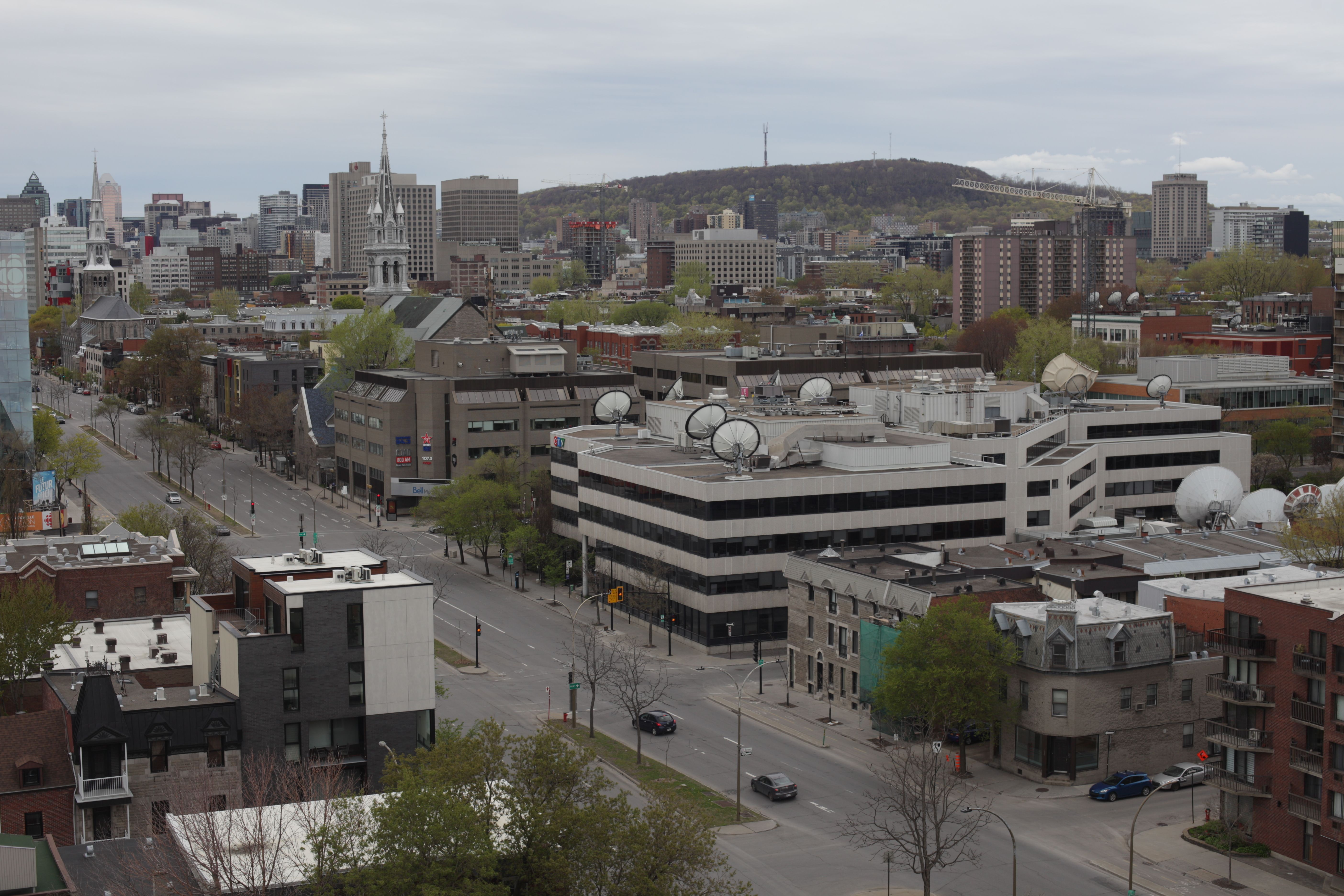 Aerial view of Montreal cityscape with Mount Royal and urban skyline on a cloudy day.