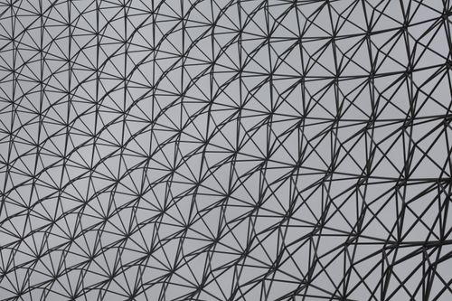 Free Abstract view of a geometric steel structure with triangular patterns against a grey sky. Stock Photo