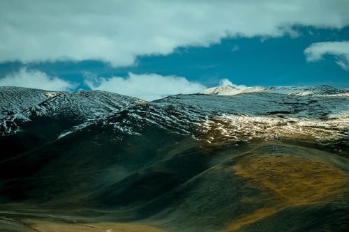Free Majestic view of a snow-capped mountain range under a bright blue sky, perfect for travel and nature themes. Stock Photo