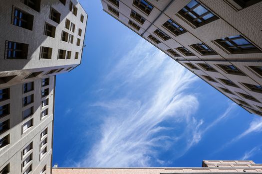 Upward view of modern buildings against a vibrant blue sky in Hamburg, Germany.