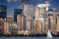 黄昏时分，帆船点缀在纽约市天际线前的河流上