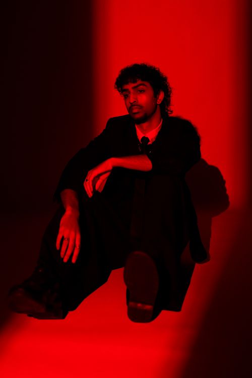 Free A striking portrait of a man in a suit under bold red lighting, evoking intensity and drama. Stock Photo