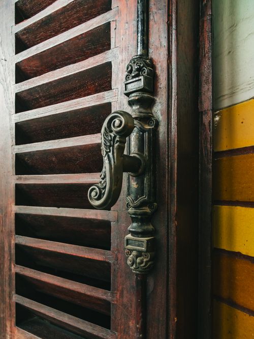 Free Close-up of a traditional Javanese wooden door with ornate vintage handle, showcasing craftsmanship. Stock Photo