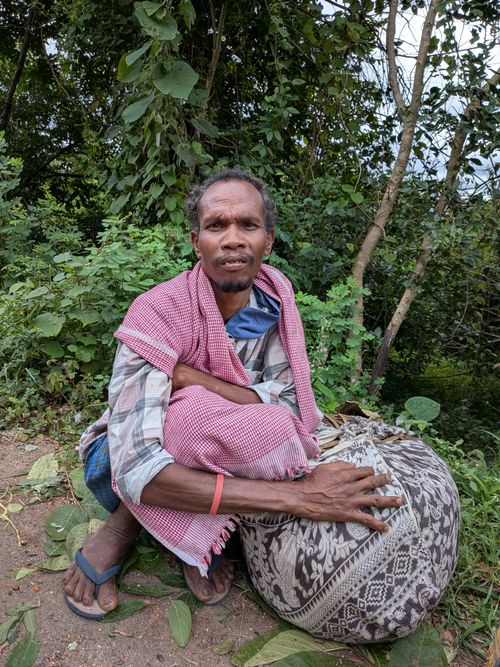 Free A tribal man sits outdoors in the lush greenery of Araku Valley, India, depicting rural life. Stock Photo