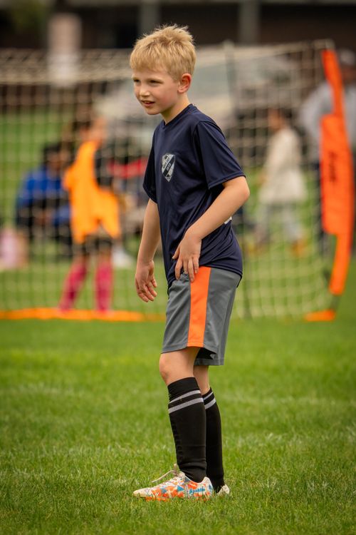 Free Young boy in sports gear playing soccer on a grassy field in Saint Paul, Minnesota. Stock Photo