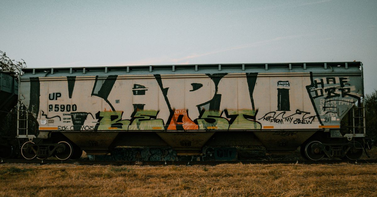 Colorful graffiti art on a stationary freight train in Edinburg, Texas during the day.