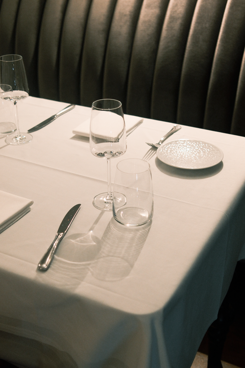 Free Sophisticated dining table setup in a restaurant setting, showcasing elegant glassware and cutlery on a white tablecloth. Stock Photo