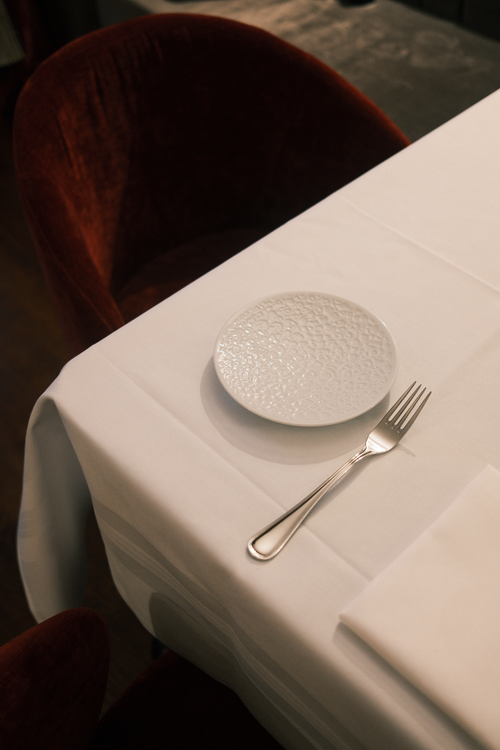 Free A sophisticated table setup with fine china and a red velvet chair in a refined setting. Stock Photo