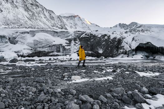 冬天，一个身穿黄色夹克的人在蒙古巴彦-厄勒邦的雪地上探索