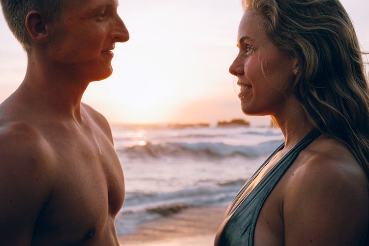 Man And A Woman At The Beach During Sunset