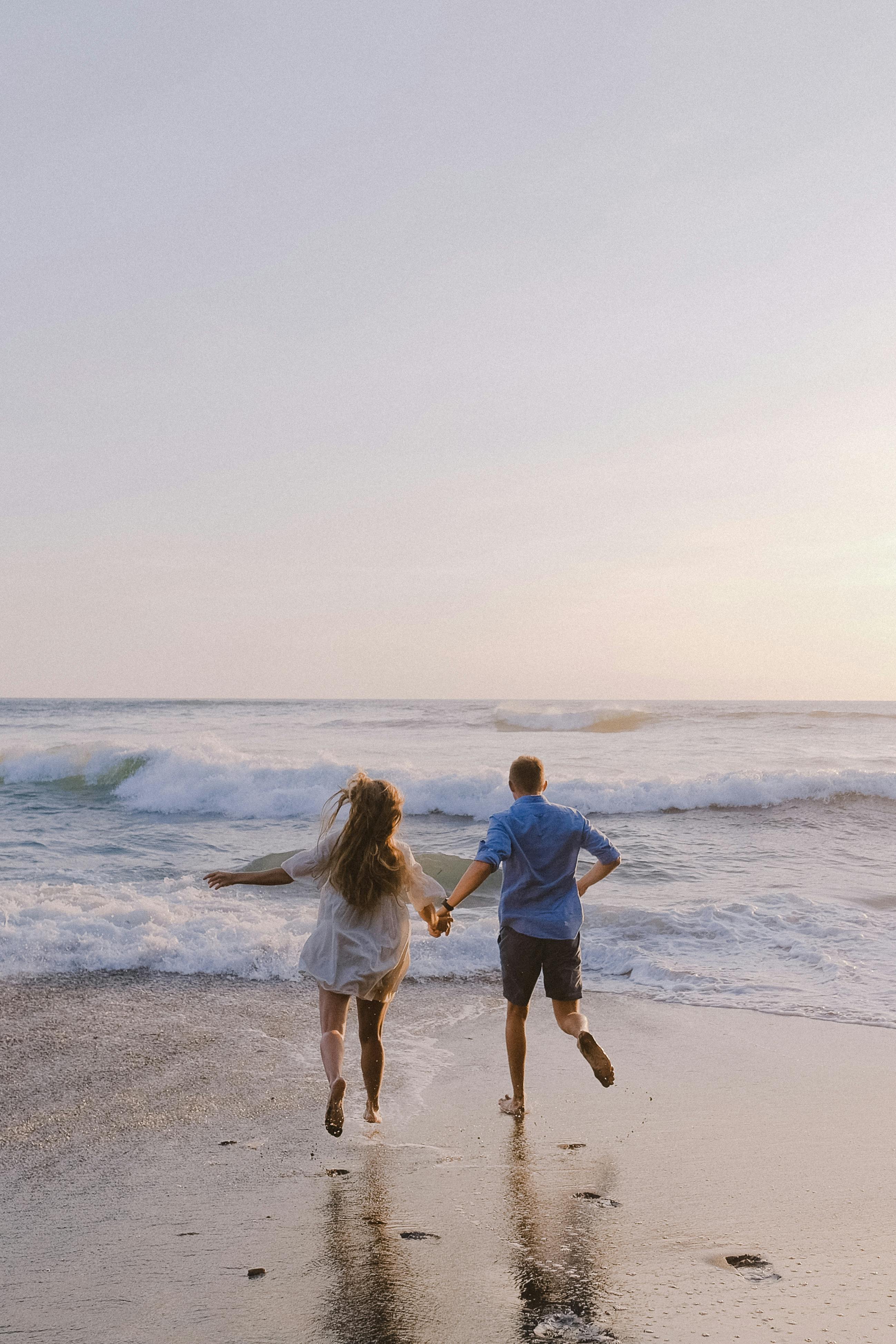 couple running together on the beach