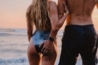 温暖的日落时分，一对夫妇在海滩上拥抱，体现了浪漫和联系