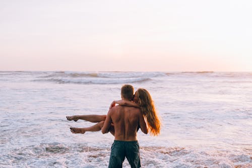 Abrazo romántico en playa al atardecer