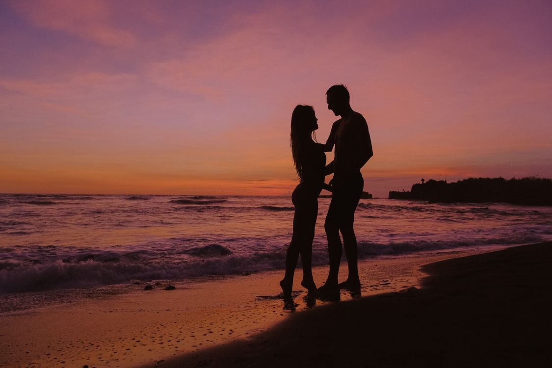 Silhouette of a Couple at the Beach during Sunset · Free Stock Photo