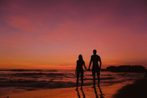 Silhouette of a Couple Standing on Shore Together