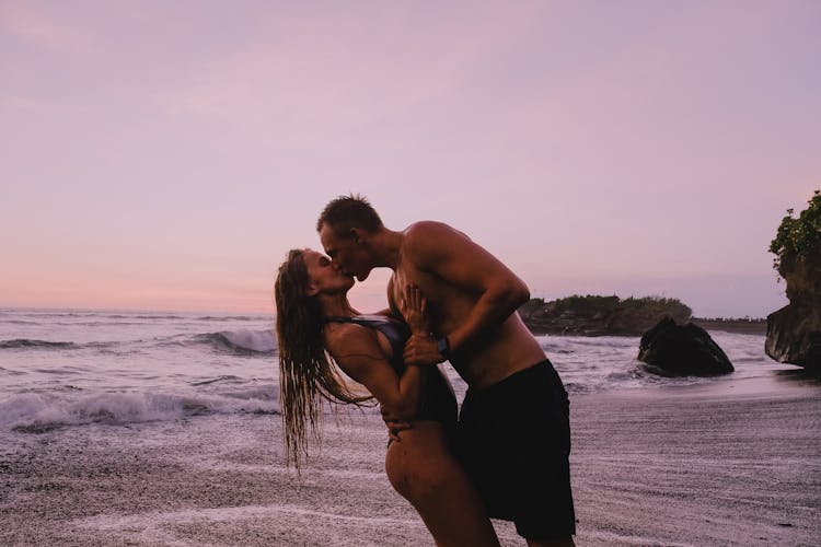 Romantic Couple Kissing During Sunset At The Beach