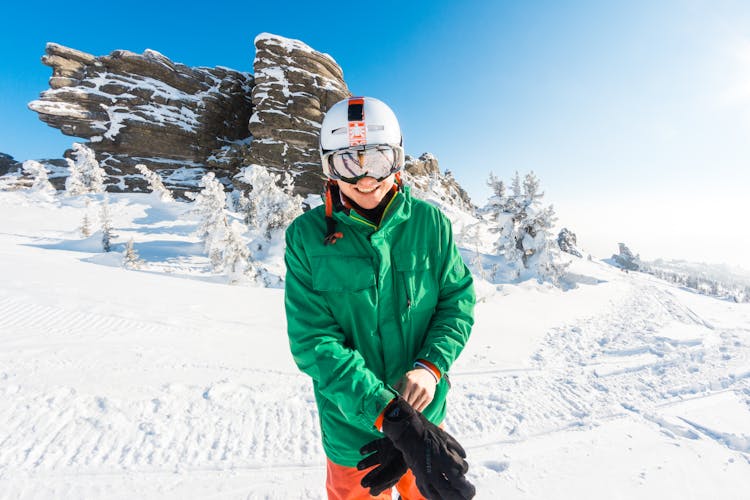 Person Wearing A Green Jacket Standing On Snow