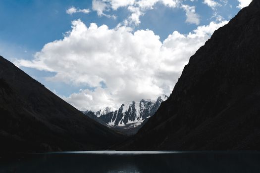 在充满活力的蓝天下，宁静的湖泊映衬着令人惊叹的山地景观